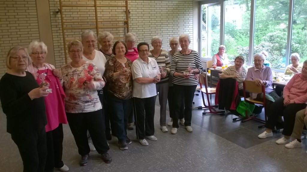 Seniorengruppe bei einer kleinen Geburtstagsfeier in der Halle
